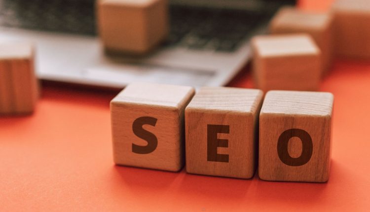 مكعبات خشبية تكوّن كلمة SEO فوق لوحة مفاتيح لابتوب